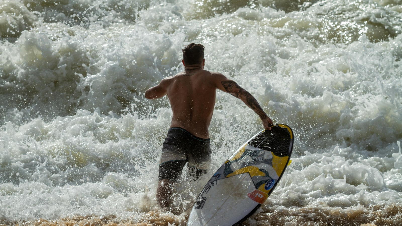 Why do surfers run with their boards?