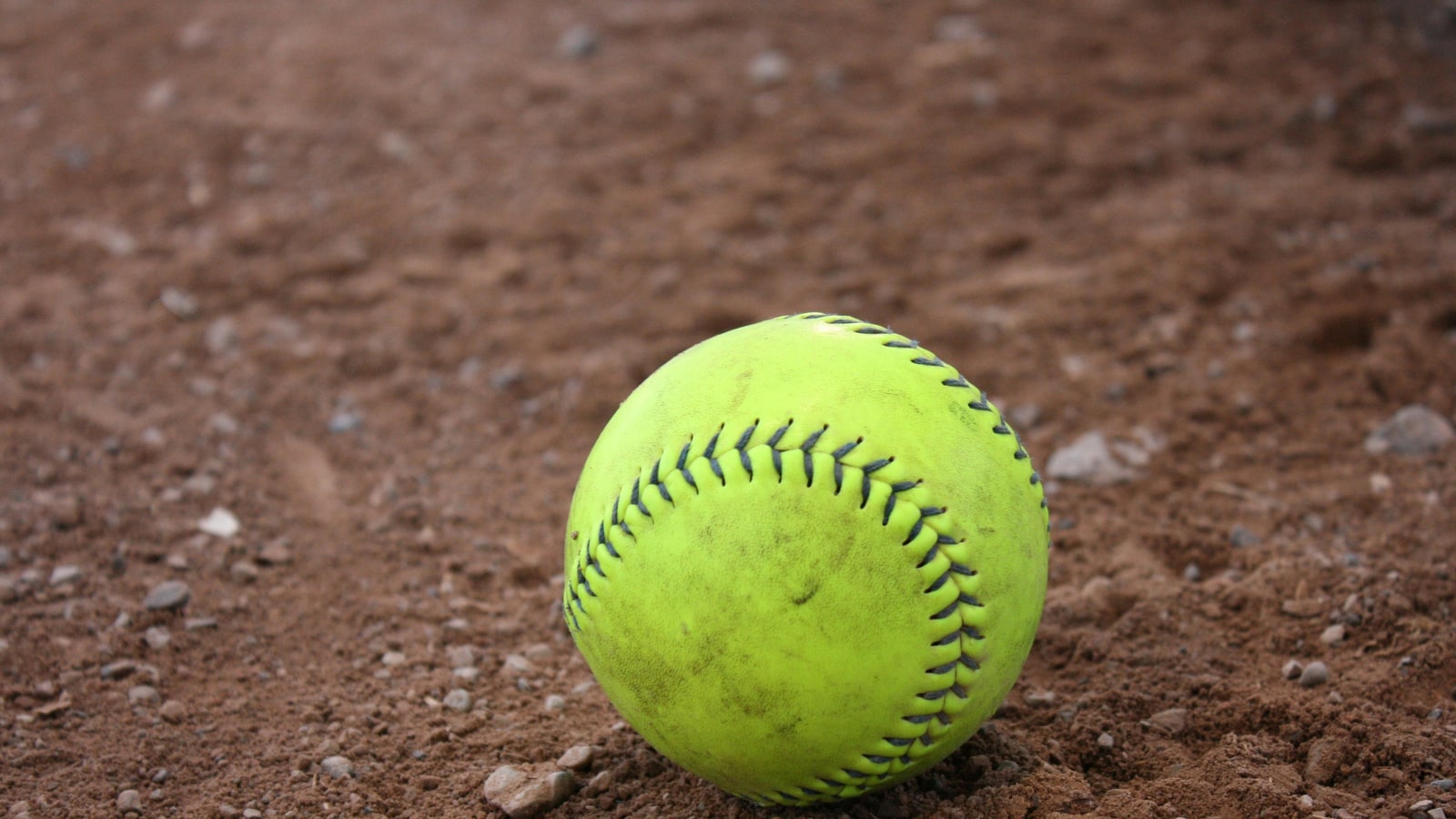 Why do women use a bigger ball in softball?