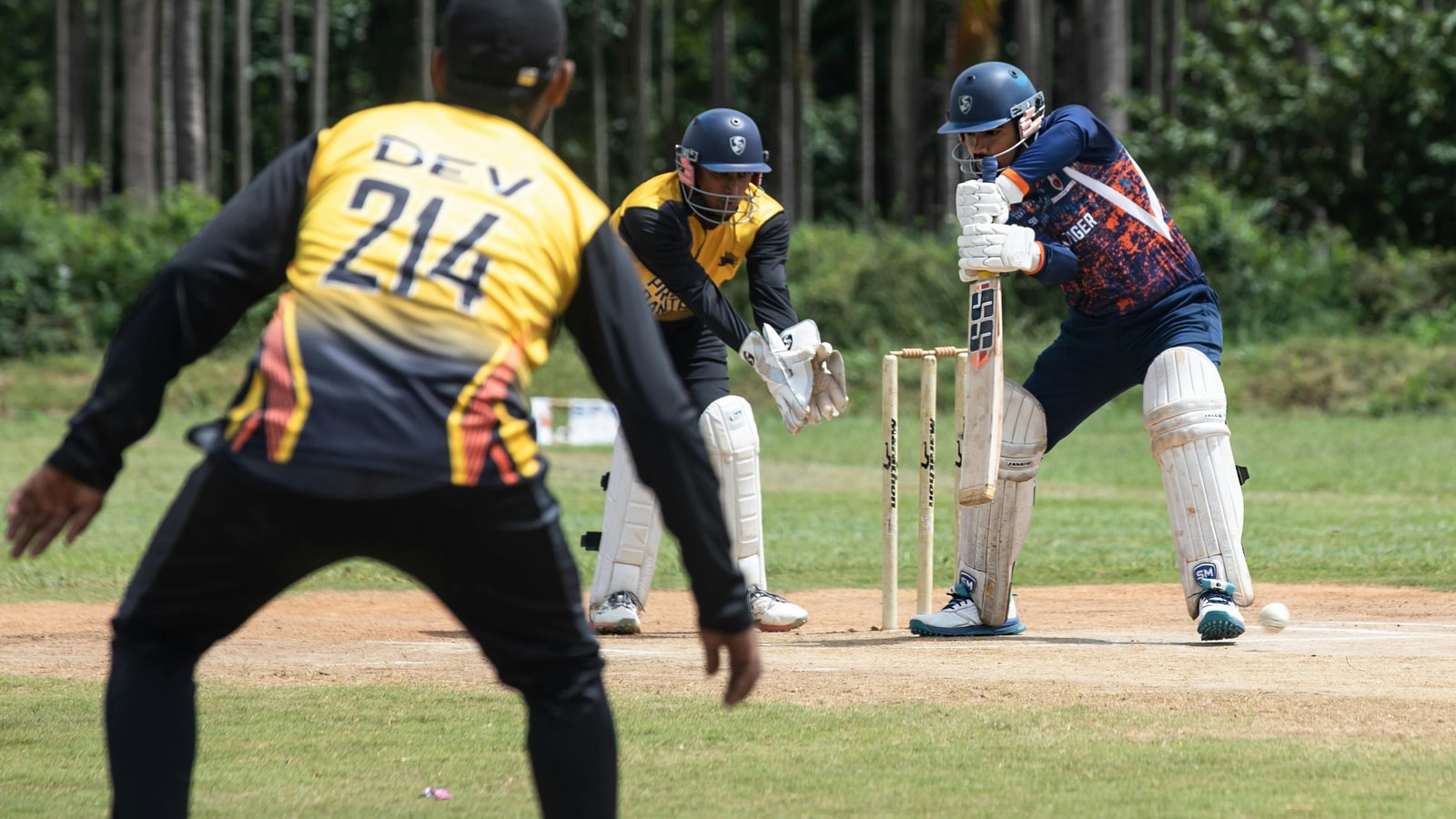 Where does a wicketkeeper stand when a bowler is bowling?