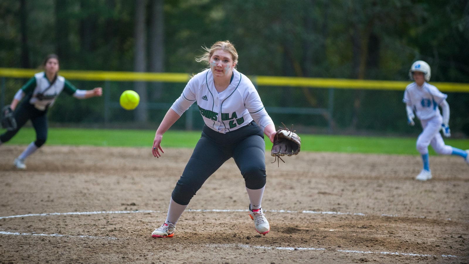 Why does a softball pitcher use a windmill to wind up?